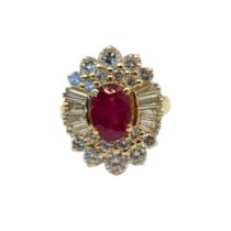 AN 18CT GOLD, RUBY AND DIAMOND CLUSTER RING The central oval cut ruby,edged with baguette and