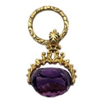 A VICTORIAN YELLOW METAL AND AMETHYST SWIVEL FOB Faceted cut stone in a textured mount. (approx
