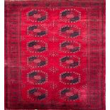 A BOKHARA WOOLLEN RUG Having twelve large red and black elephant foot motifs to red central