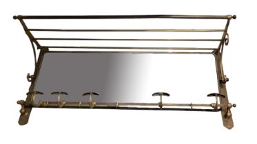 AN EDWARDIAN POLISHED BRASS WALL MOUNTED COAT RACK With turn gallery above a bevelled plated swing