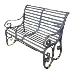 A VICTORIAN WROUGHT IRON TWO SEAT GARDEN BENCH With strap work seat and back on scrolling arms and