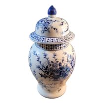 A LARGE CONTINENTAL BLUE AND WHITE POTTERY GINGER JAR AND COVER Decorated with flowers and fans. (