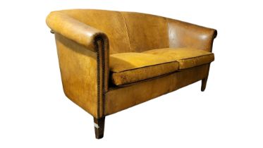 A FRENCH ART DECO TAN SHEEPSKIN LEATHER UPHOLSTERED TWO SEAT SETTEE With two loose cushions, on