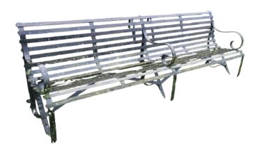 A VICTORIAN WROUGHT IRON FOUR SEAT GARDEN BENCH With strap work seat and back, three scroll arms and