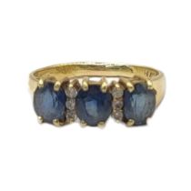 AN 18CT GOLD, SAPPHIRE AND DIAMOND THREE STONE RING Three oval cut stones interspersed with two rows