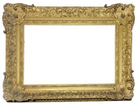A LATE 19TH/EARLY 20TH CENTURY GILDED RECTANGULAR PICTURE FRAME With carved scrolled decoration