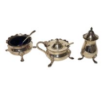 AN EARLY 20TH CENTURY SILVER AND BLUE GLASS CRUET SET Comprising a pepperette, salt pot, mustard pot