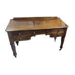 A VICTORIAN MAHOGANY KNEEHOLE DRESSING TABLE With an arrangement of three drawers, raised on