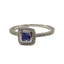 A 9CT WHITE GOLD, SAPPHIRE AND DIAMOND RING The central square cut stone,edged with diamonds with