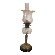 A VICTORIAN BRASS AND CUT GLASS OIL LAMP Having a fluted glass shade, cut glass oil well and twisted