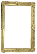 AN EARLY 20TH CENTURY GILDED RECTANGULAR PICTURE FRAME With carved scrolled decoration. (aperture