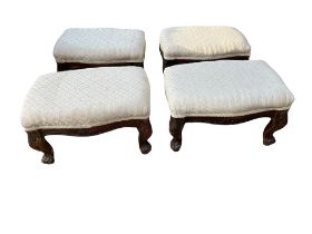 A SET OF FOUR VICTORIAN STYLE STOOLS In cream fabric overstuffed upholstery, on carved cabriole