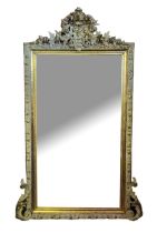 A LATE 19TH/EARLY 20TH CENTURY GILT AND CREAM FRAMED MIRROR With elaborate floral crest above