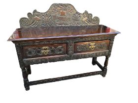 A 19TH CENTURY HEAVILY CARVED OAK SIDEBOARD In Jacobean style, with shaped backboard above two