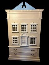 A CHILD'S LINEN PRESS IN THE FORM OF A DOLL'S HOUSE With architectural pediment above two doors