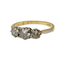 AN 18CT GOLD AND DIAMOND THREE STONE RING Having a single row of round cut diamonds. (approx total
