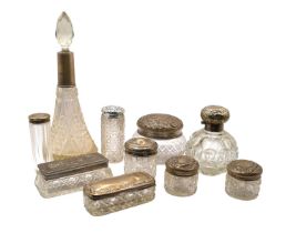 A COLLECTION OF TEN EDWARDIAN AND LATER SILVER TOPPED GLASS PERFUME BOTTLES AND BOXES Comprising