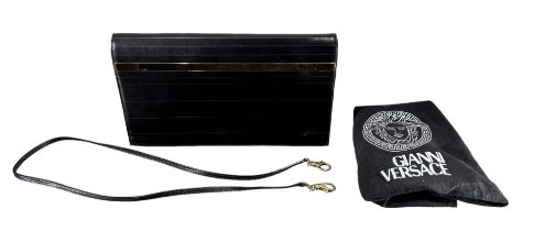 GIANNI VERSACE, A BLACK LEATHER AND GOLD TONED CLUTCH BAG Having interior and felt lined bag. (