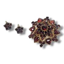 A VICTORIAN STYLE YELLOW METAL AND GARNET BROOCH & SIMILAR WHITE METAL EARRINGS. YELLOW METAL TESTED
