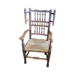 A 19TH CENTURY LANCASHIRE OAK WIING OPEN ARMCHAIR With turned spindles, rush seat turned kegs and