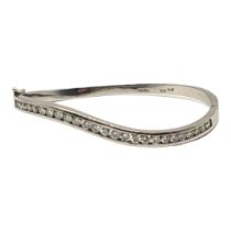 PETER, AN 18CT WHITE GOLD AND DIAMOND BANGLE The row of round cut diamonds in a wave design,