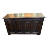 A 19TH CENTURY OAK COFFER The four panelled front carved with medieval figures, flanked by reeded