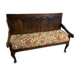 AN 18TH CENTURY OPEN ARM OAK SETTLE With four ogee panelled back, floral tapestry upholstered
