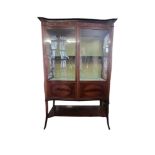 AN EDWARDIAN MAHOGANY AND MARQUETRY INLAID DISPLAY CABINET With two serpentine glazed and oval
