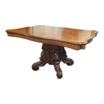 A 19TH CENTURY MAHOGANY DINING TABLE With cartouche top, raised on a heavily carved pedestal, with