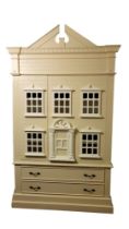 A CHILD'S LINEN PRESS IN THE FORM OF A DOLL'S HOUSE With architectural pediment above two doors