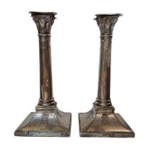 A PAIR OF VICTORIAN SILVER CANDLESTICKS Classical column form with embossed swags to base,