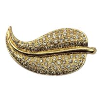 A 14CT GOLD AND DIAMOND LEAF FORM BROOCH Having an arrangement of graduated round cut stones in a