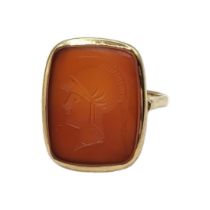 A VINTAGE YELLOW METAL AND CARNELIAN INTAGLIO RING Rectangular cut stone with classical male