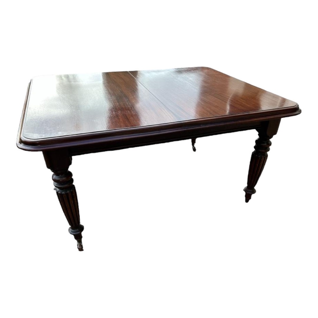 A VICTORIAN MAHOGANY EXTENDING DINING TABLE With two extra leaves, raised on turned and reeded