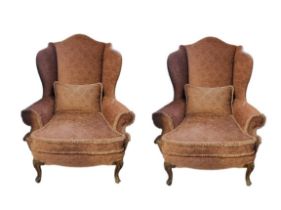 A PAIR OF GEORGIAN STYLE WING ARMCHAIRS In salmon pink fabric upholstery, complete loose cushions,
