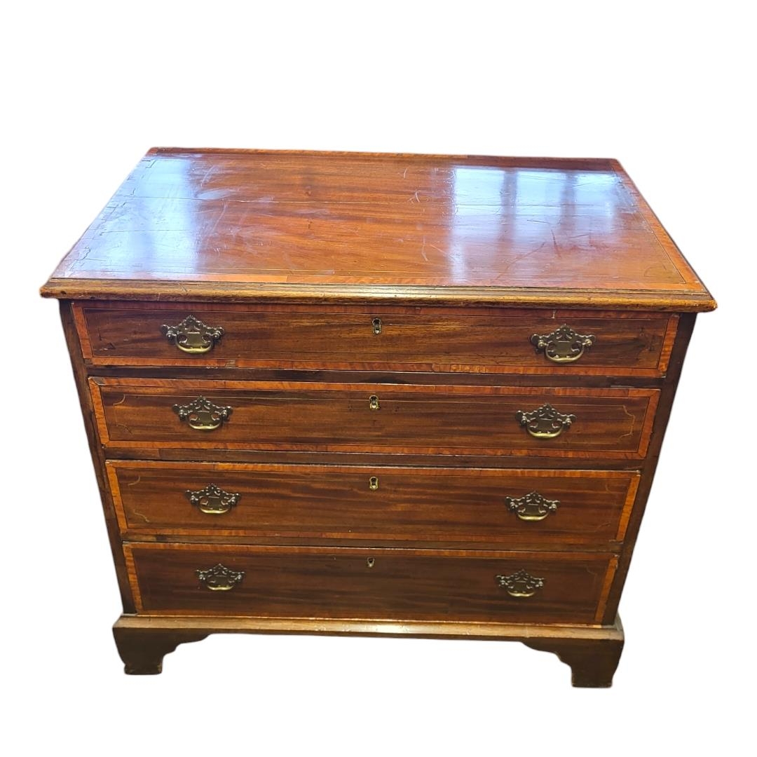 A 19TH CENTURY MAHOGANY AND SATINWOOD BANDED SHERATON DESIGN CHEST OF FOUR LONG DRAWERS On bracket