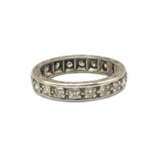 A VINTAGE WHITE METAL AND DIAMOND ETERNITY RING The single row of round cut diamonds in an
