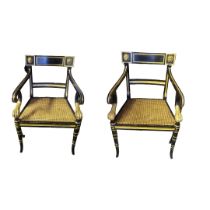 A PAIR OF REGENCY STYLE GILT AND EBONISED OPEN ARMCHAIRS With applied carved lion mask top rail,