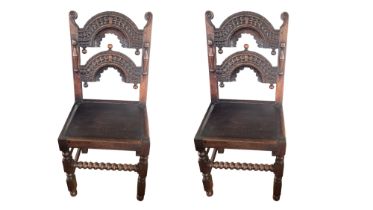 A PAIR OF 17TH CENTURY STYLE CARVED OAK STANDARD CHAIRS With humpback rails solid seats on square