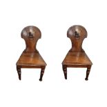 CHARLES ROODHOUSE, A PAIR OF VICTORIAN OAK HALL CHAIRS The panelled backs applied with armorial