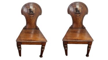 CHARLES ROODHOUSE, A PAIR OF VICTORIAN OAK HALL CHAIRS The panelled backs applied with armorial