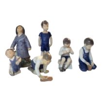 BING & GRØNDAHL, A SET OF FOUR HARD PASTE PORCELAIN MODELS OF YOUNG BOYS Blue and white lustre