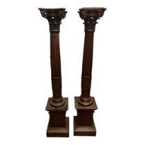 A PAIR OF 19TH CENTURY AND LATER OAK TORCHERES With finely carved acanthus scroll Corinthian