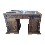 A LATE 19TH/EARLY 20TH CENTURY CARVED OAK PEDESTAL DESK With tooled leather surface above an