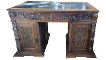A LATE 19TH/EARLY 20TH CENTURY CARVED OAK PEDESTAL DESK With tooled leather surface above an