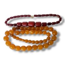 A 20TH CENTURY CHERRY AMBER BEAD NECKLACE Graduated cylindrical beads with yellow metal clasp,