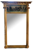 A 19TH CENTURY GILT FRAMED TRUMEAU MIRROR The reverse glass painted riverside landscape flanked by