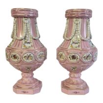 A PAIR OF CONTINENTAL BALUSTER PORCELAIN VASES With classical applied swags, floral decoration on