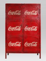 A DECORATIVE PAINTED STEEL COCA COLA LOCKER With embossed doors opening to reveal shelf interior