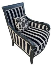 AN EBONISED EMPIRE DESIGN UPHOLSTERED ARMCHAIR.